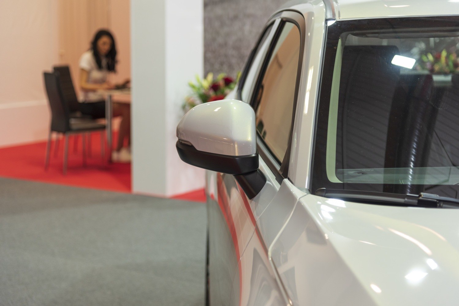 Close-up of vehicle side mirror and front window with reflections