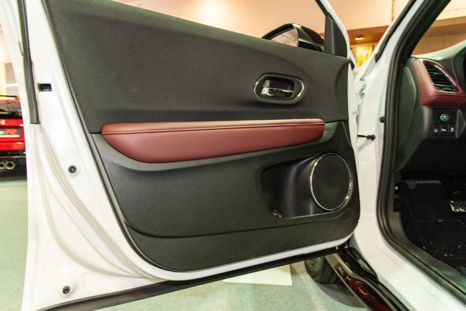 Car interior door panel with speaker, door handle, and leather armrest