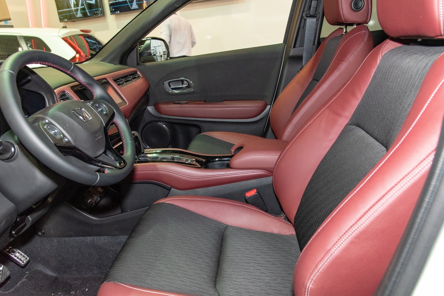 Two-tone red and black seats with modern dashboard and steering wheel.