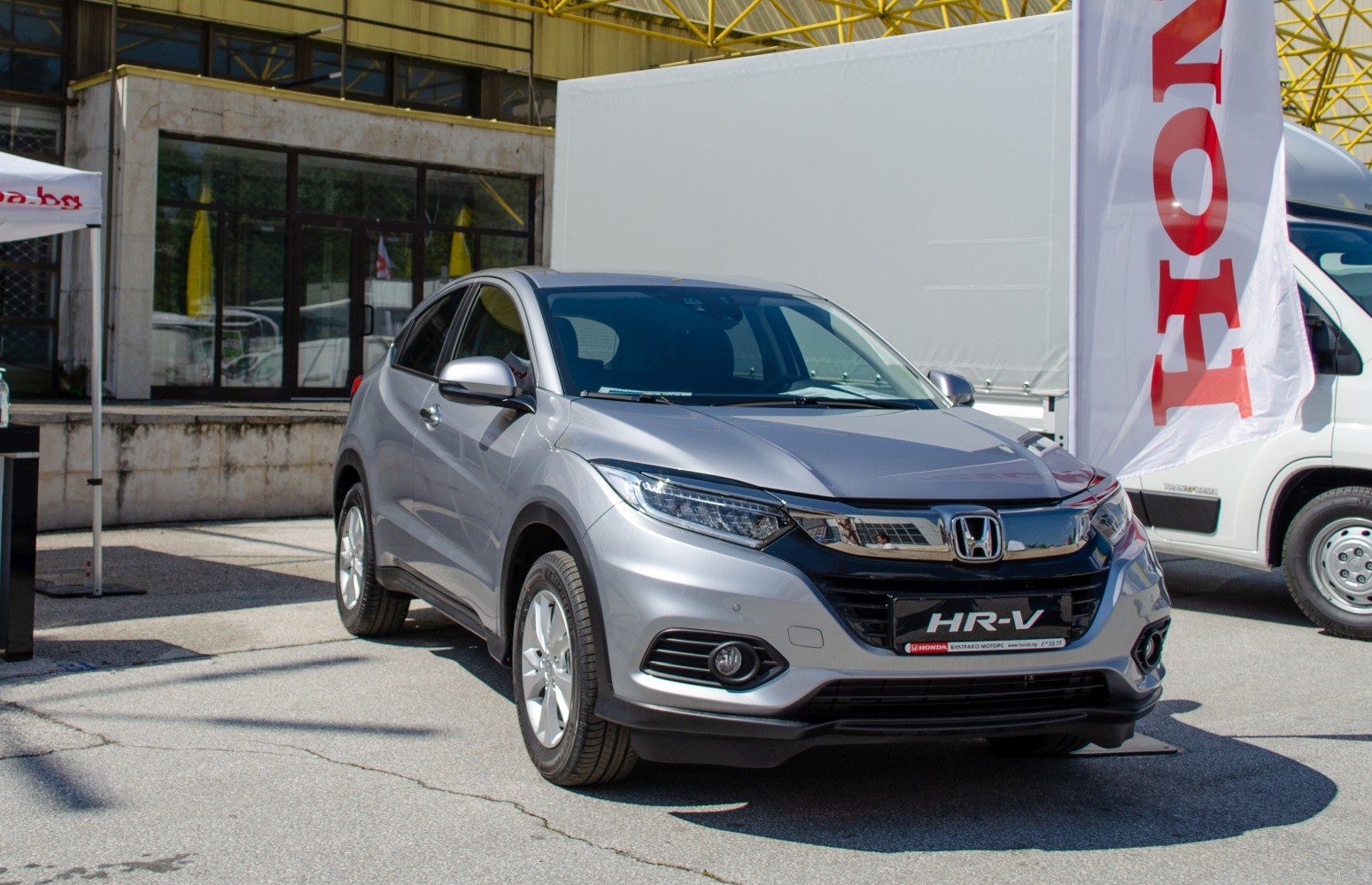 Front three-quarter view of a silver crossover SUV with LED headlights and chrome grille