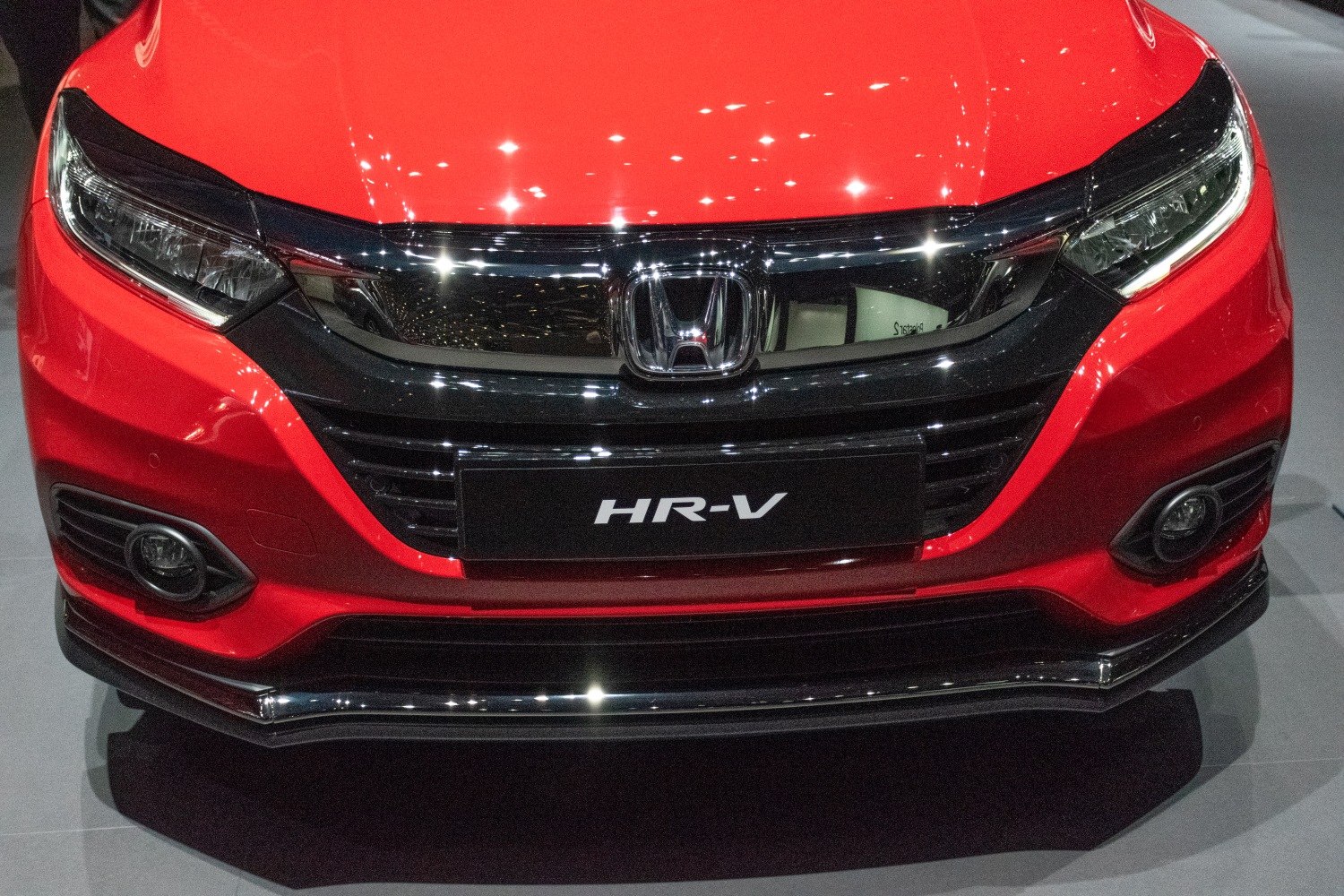 Front grille, headlights, and fog lights of a red vehicle