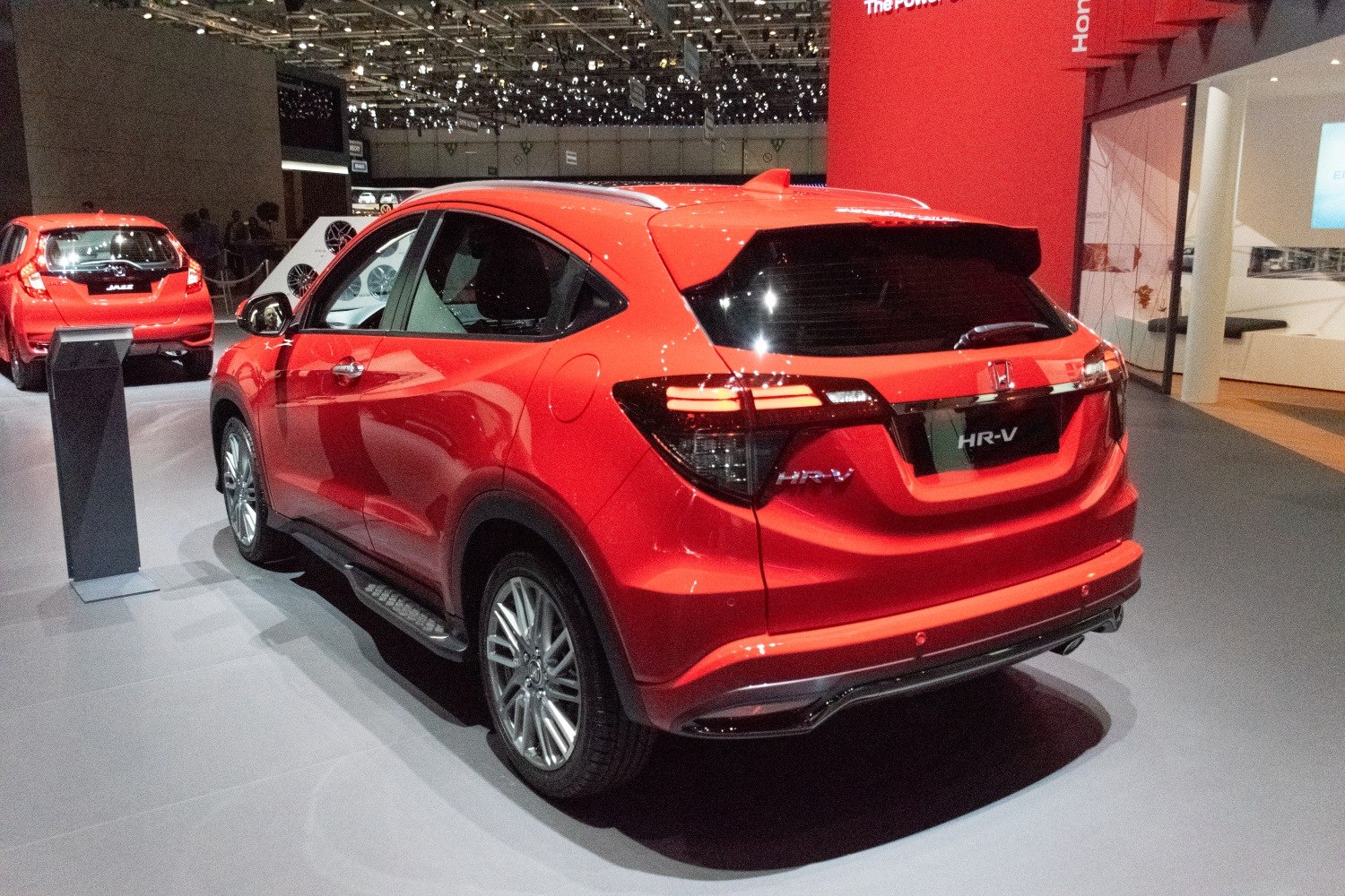 Red SUV rear with LED tail lights and roof spoiler in showroom