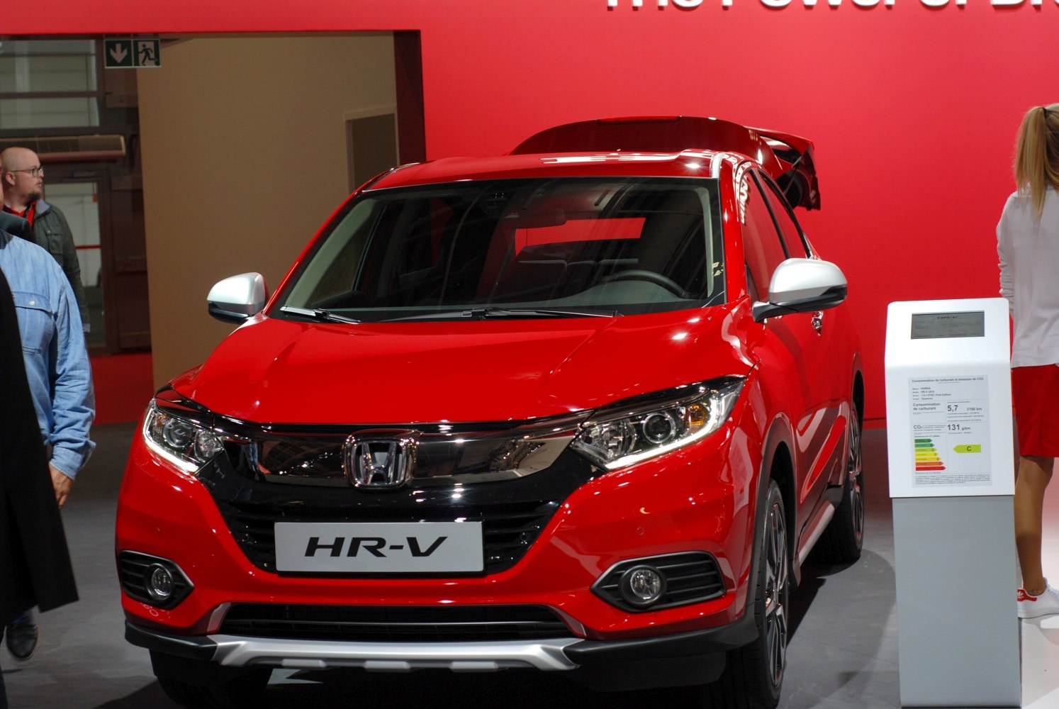 Front view of red compact SUV with LED headlights and a prominent grille