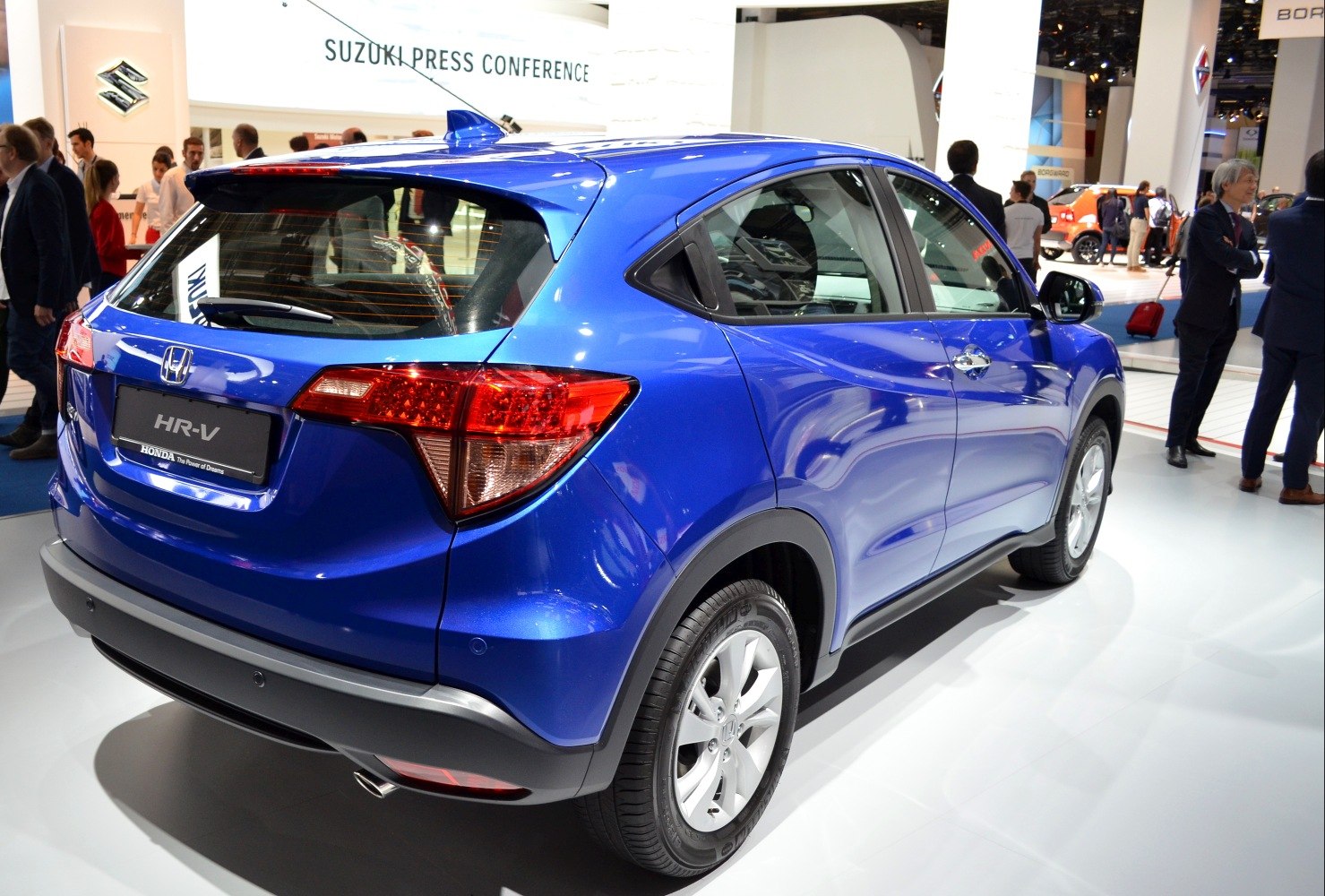 Rear side view of blue compact SUV with distinctive tail lights and rear window wiper
