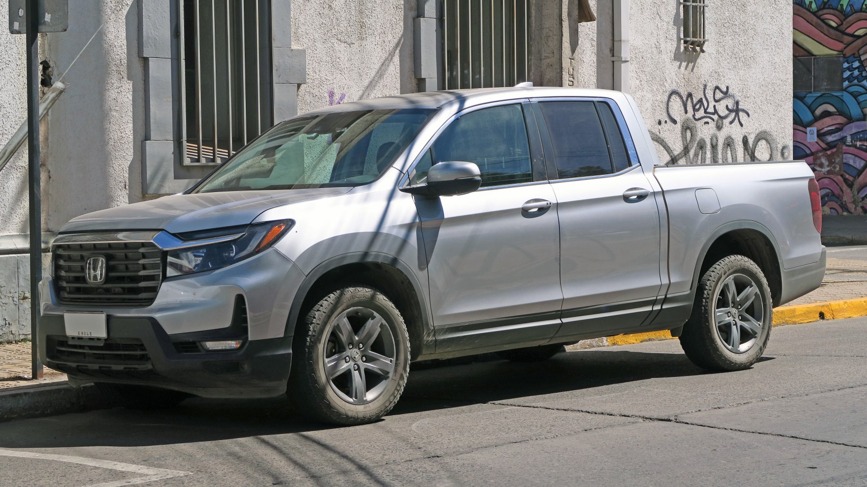 Silver four-door pickup with black grille and alloy wheels