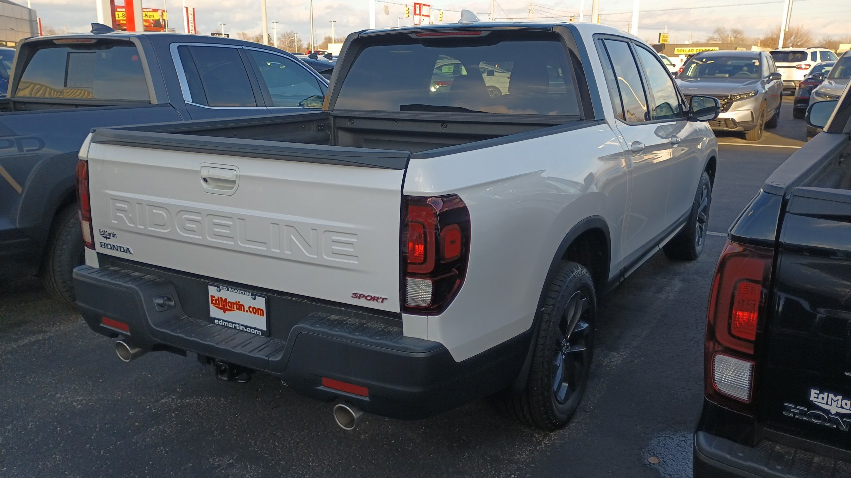 Rear view of a white pickup with open truck bed and modern taillights