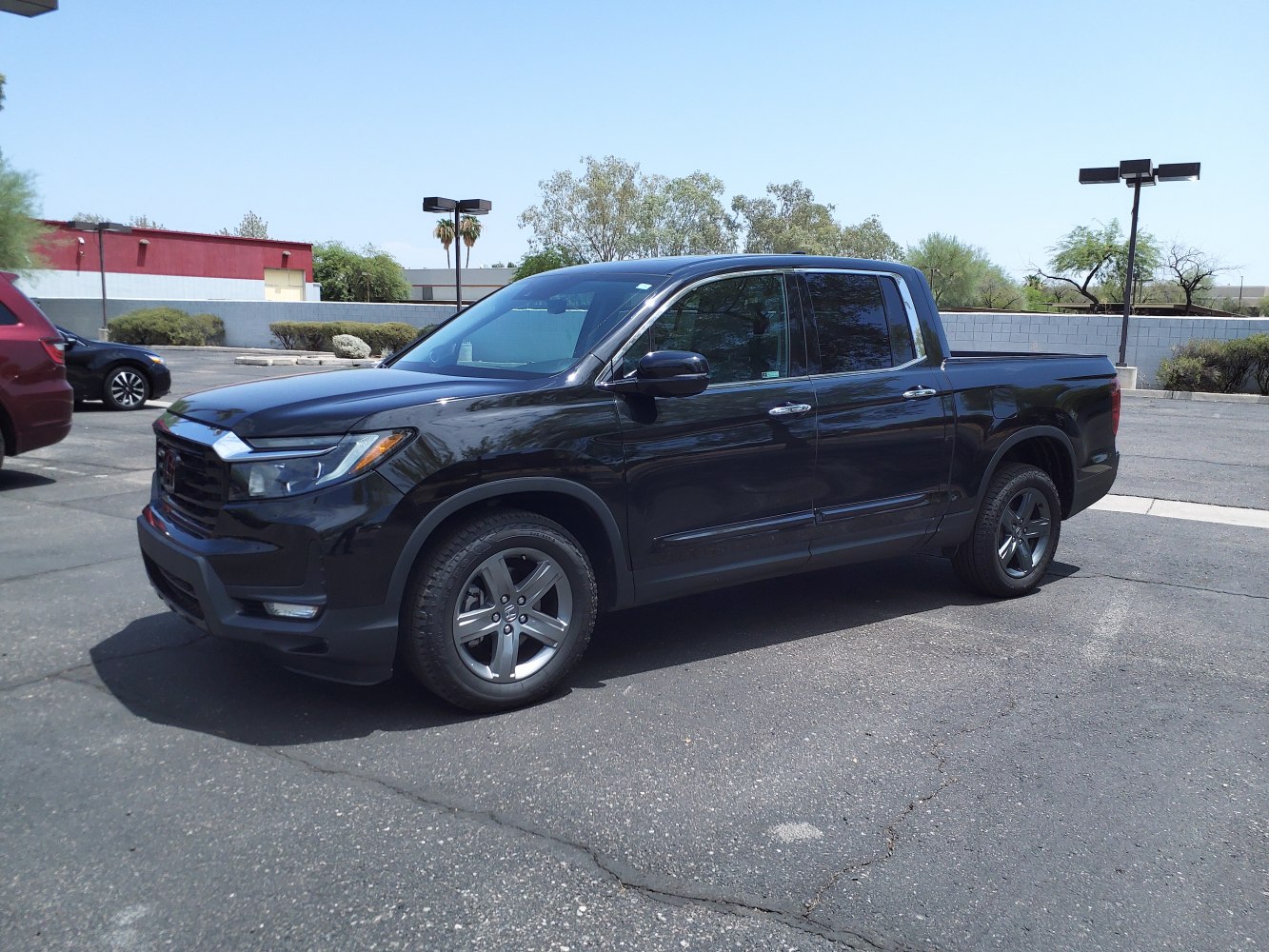 Black pickup truck with modern headlights and black alloy wheels.