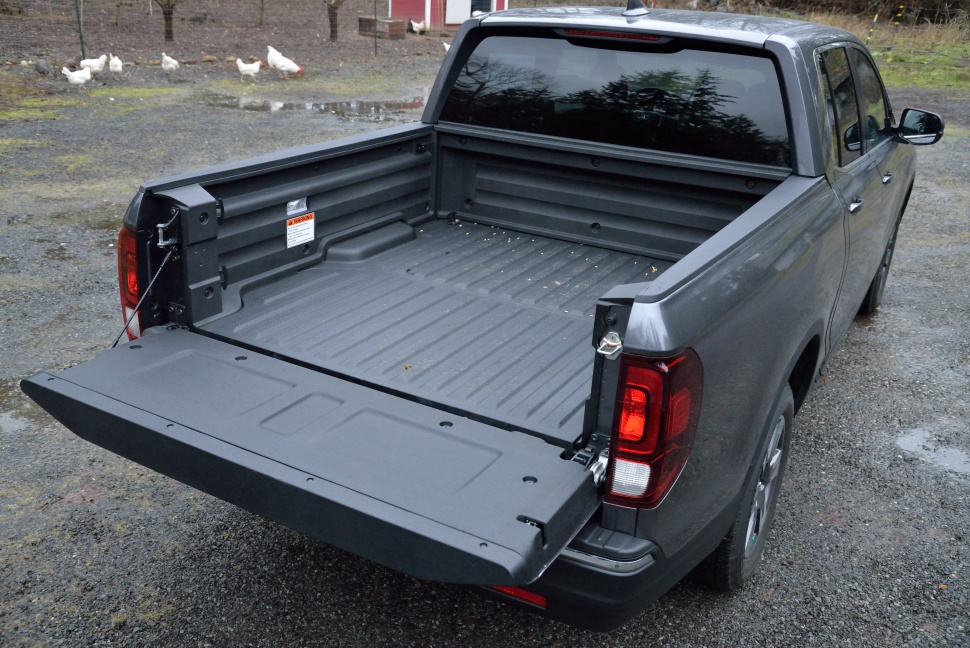 Open pickup truck bed with lowered tailgate and spacious cargo area.