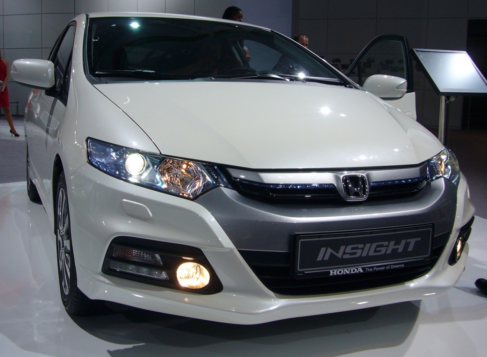 Front view with headlights and fog lights on, featuring grille and bumper details