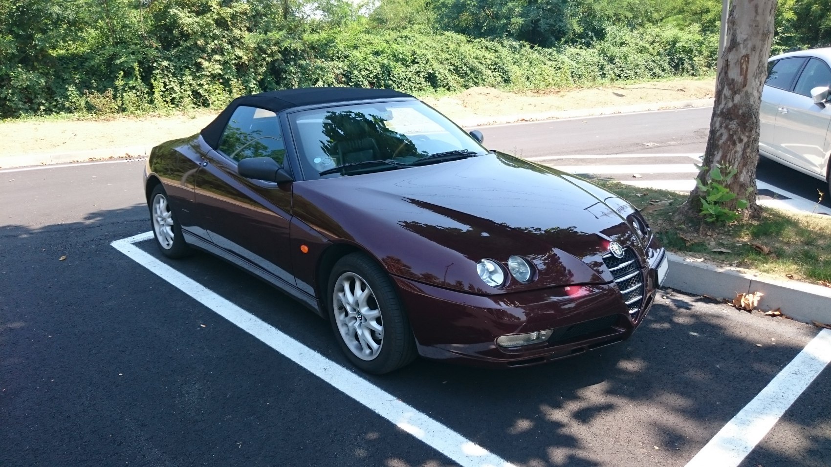Convertible roadster with distinctive quad front headlights and sleek aerodynamic design.