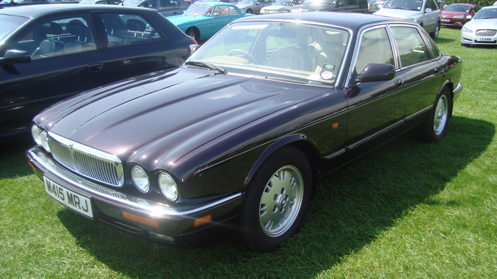 Luxury sedan with dual round headlights and chrome grille, front-side perspective