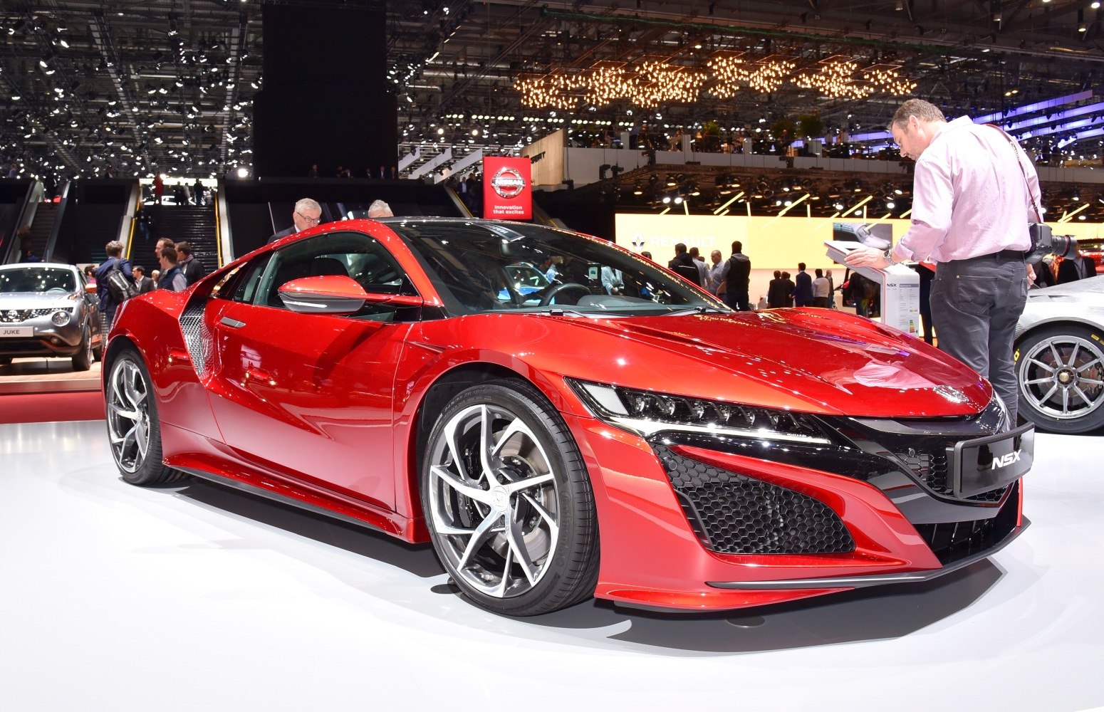 Front-side view of sleek red sports coupe with aerodynamic design and alloy wheels