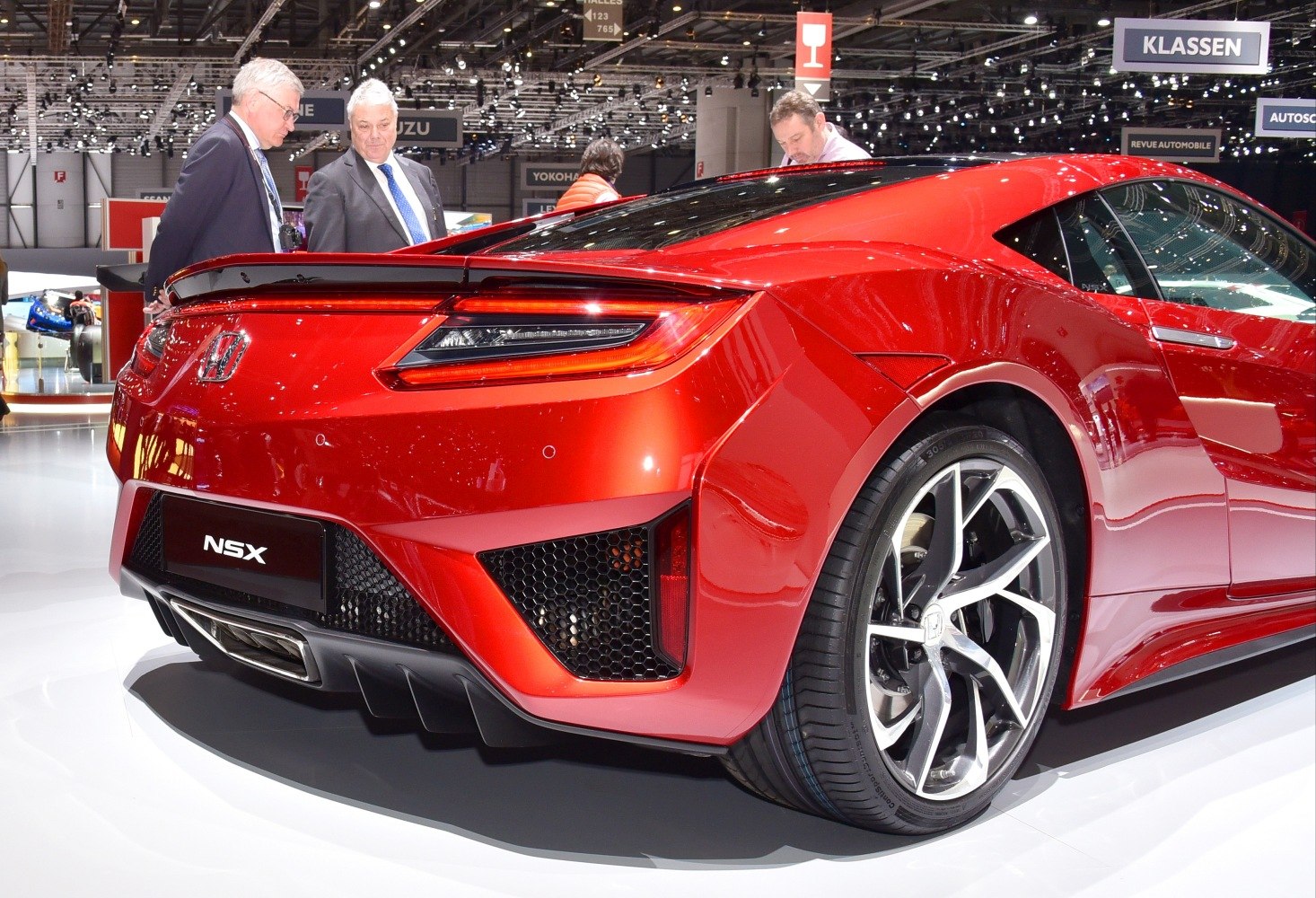 Rear view showing rear lights, spoiler, and alloy wheel of a red sports coupe.