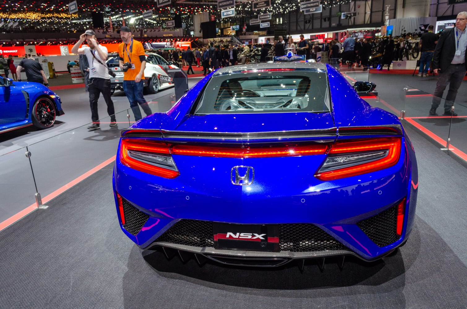 Rear view of a blue sports coupe with LED tail lights and visible engine bay.