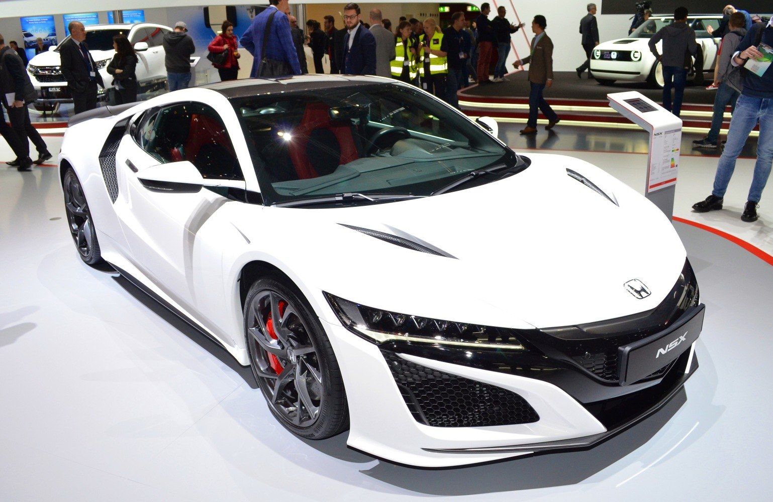 White sports car front side view with aggressive headlights and aerodynamic design