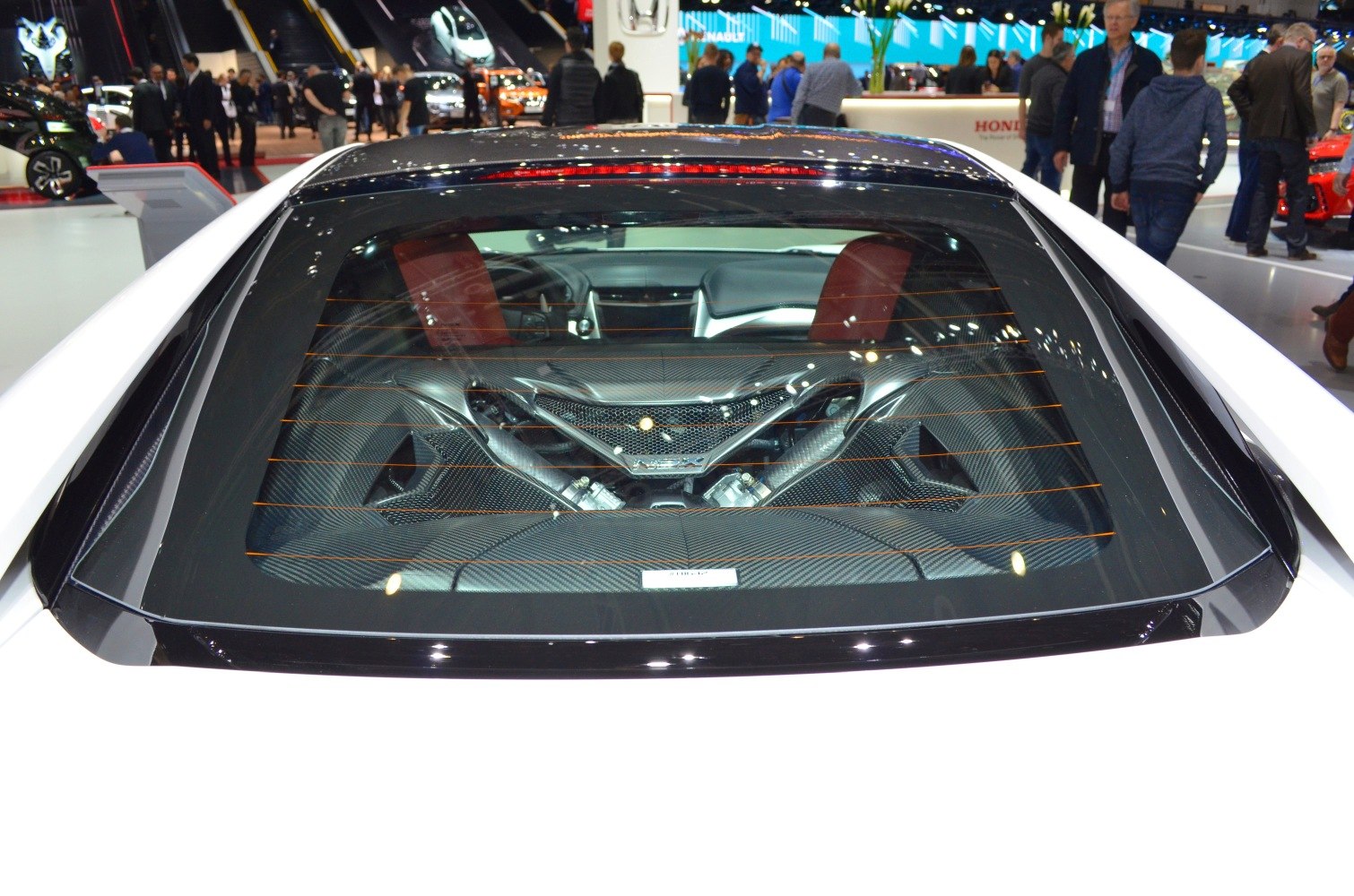 Mid-engine V6 visible through rear glass with carbon fiber detailing