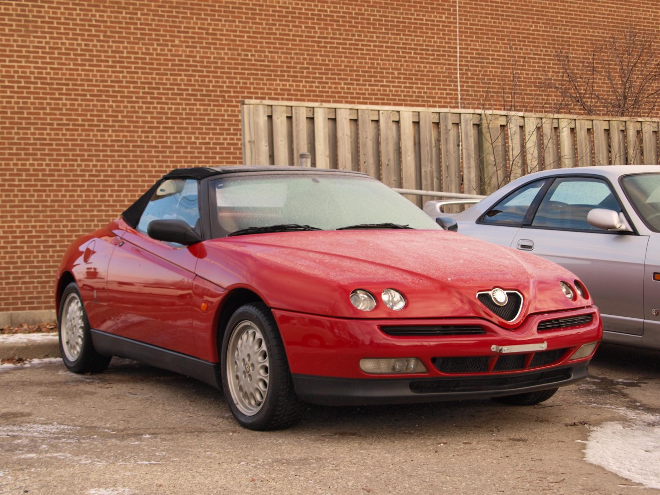 Red convertible with quad headlights and Alfa Romeo triangular grille