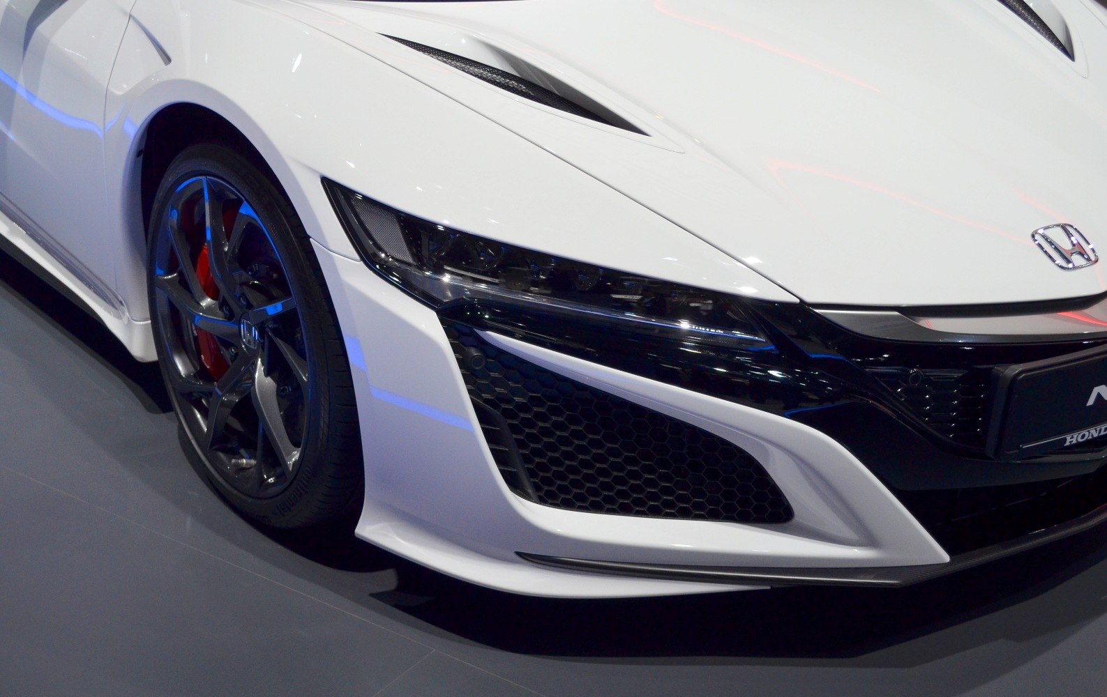 Close-up of front headlight and wheel of a sports coupe