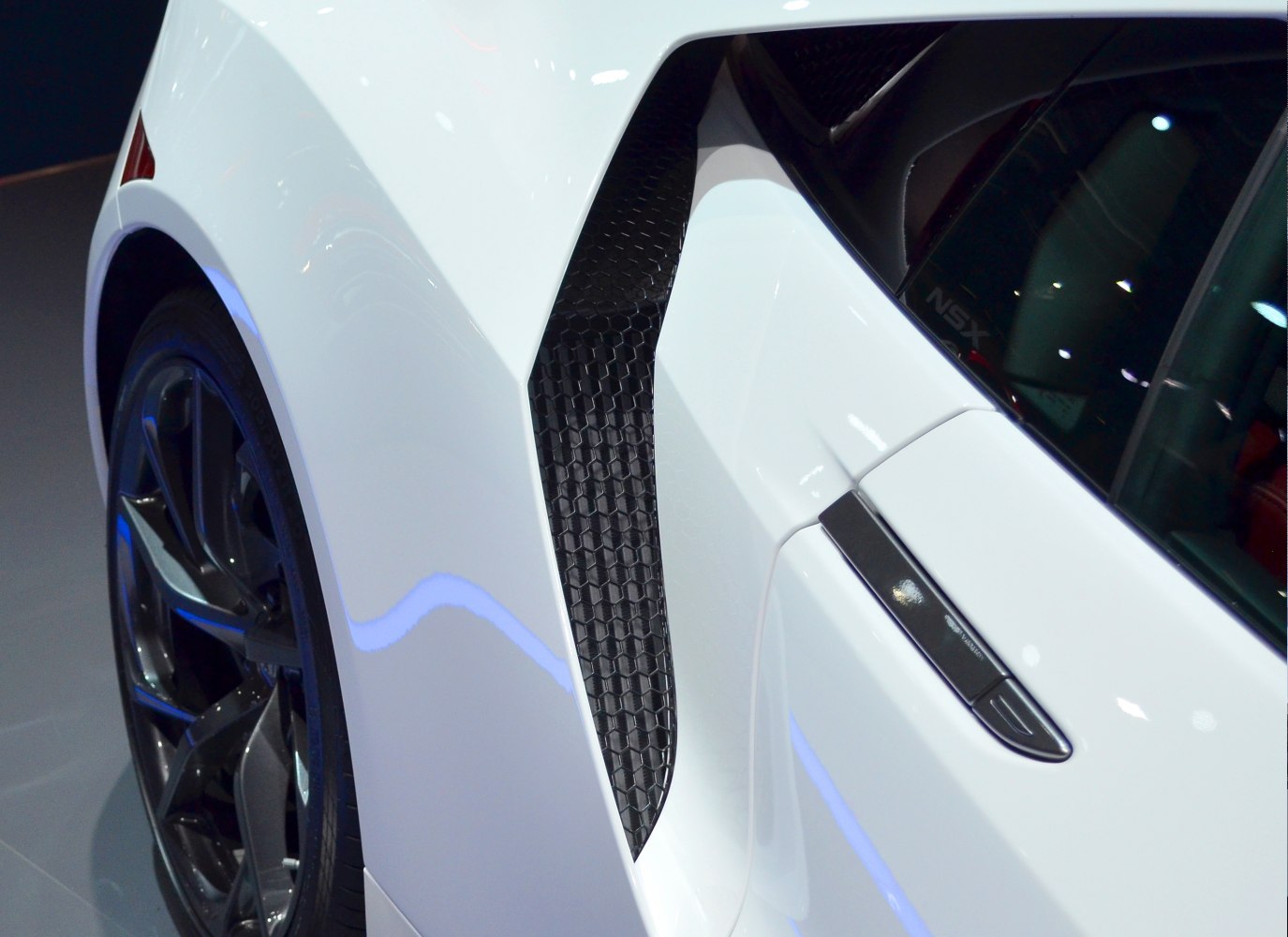 Aerodynamic side air intake and rear wheel with black alloy rim.