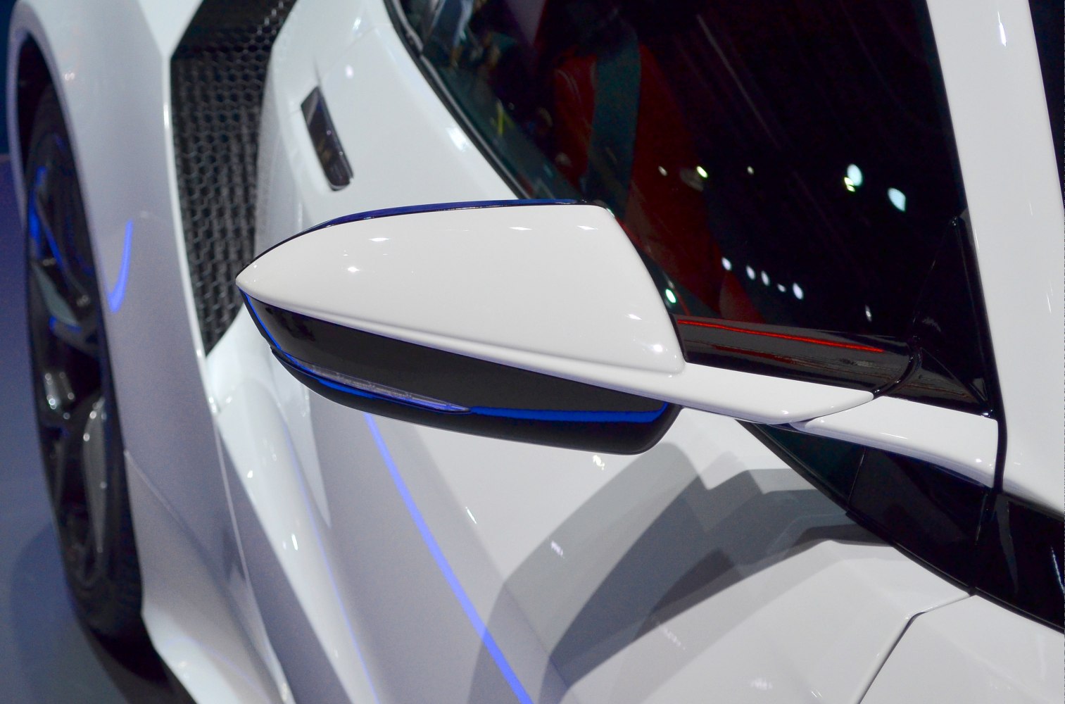 Close-up of aerodynamic side mirror and side vent detail on sports coupe.