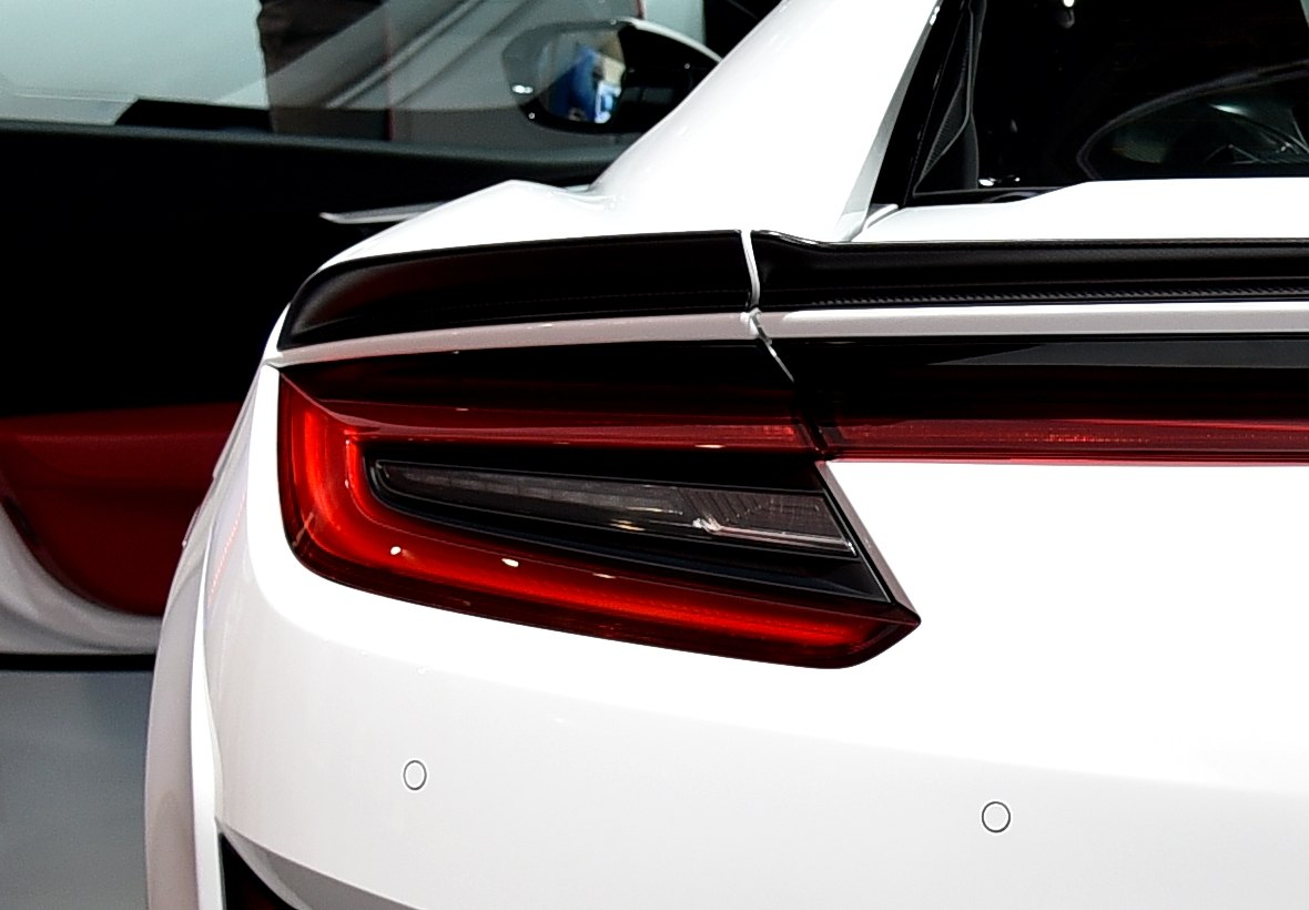 Close-up of rear LED tail light and spoiler on white sports coupe