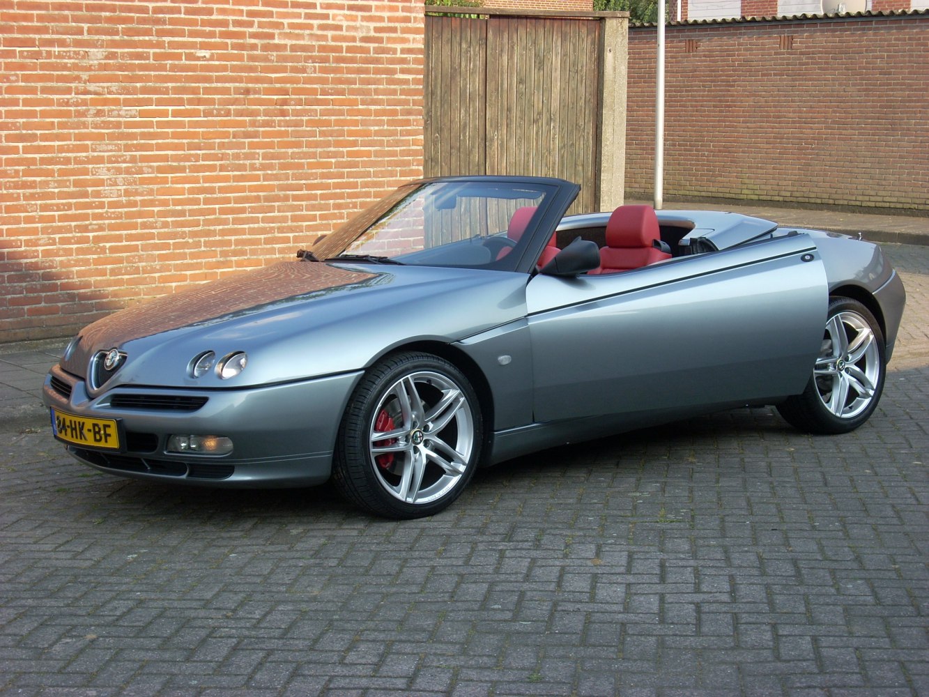 Sleek silver convertible with triple-headlights and red seats