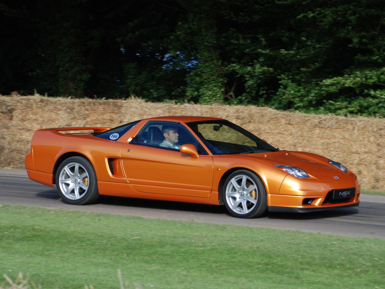 Aerodynamic orange sporty coupe with alloy wheels and side air intake