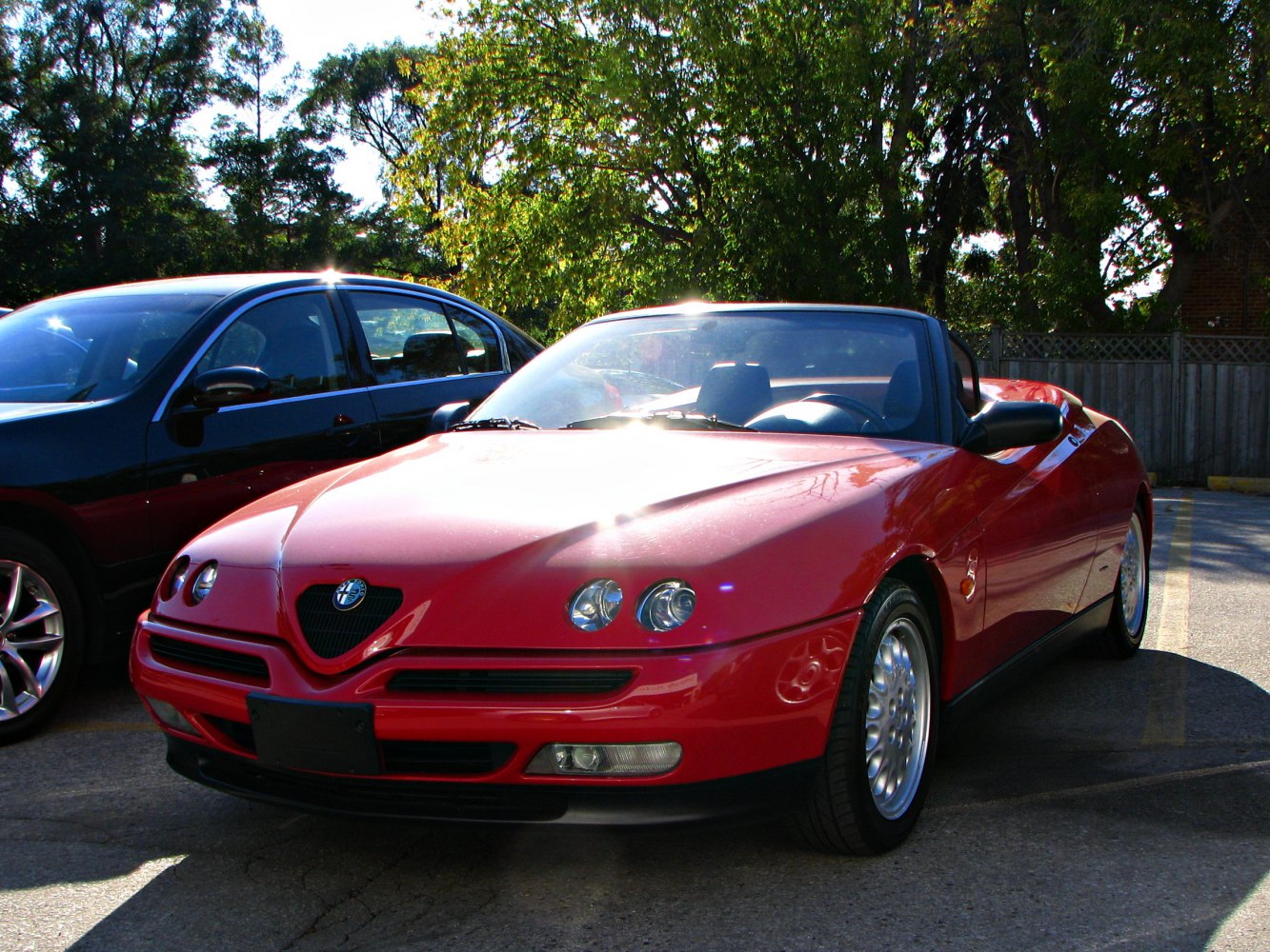 Red convertible roadster with quad round headlights and curved hood