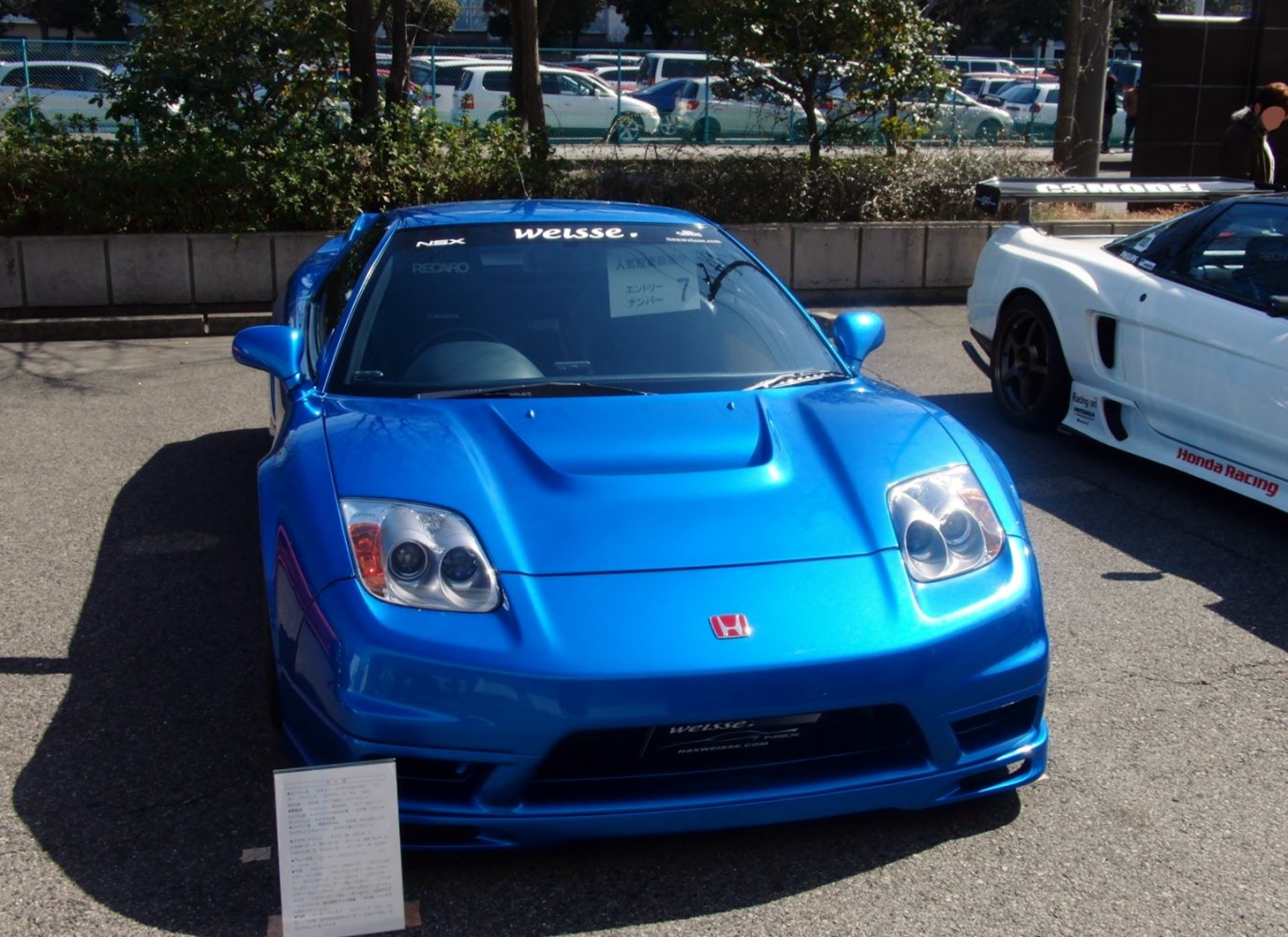 Blue sports coupe front with dual round headlights and hood scoop