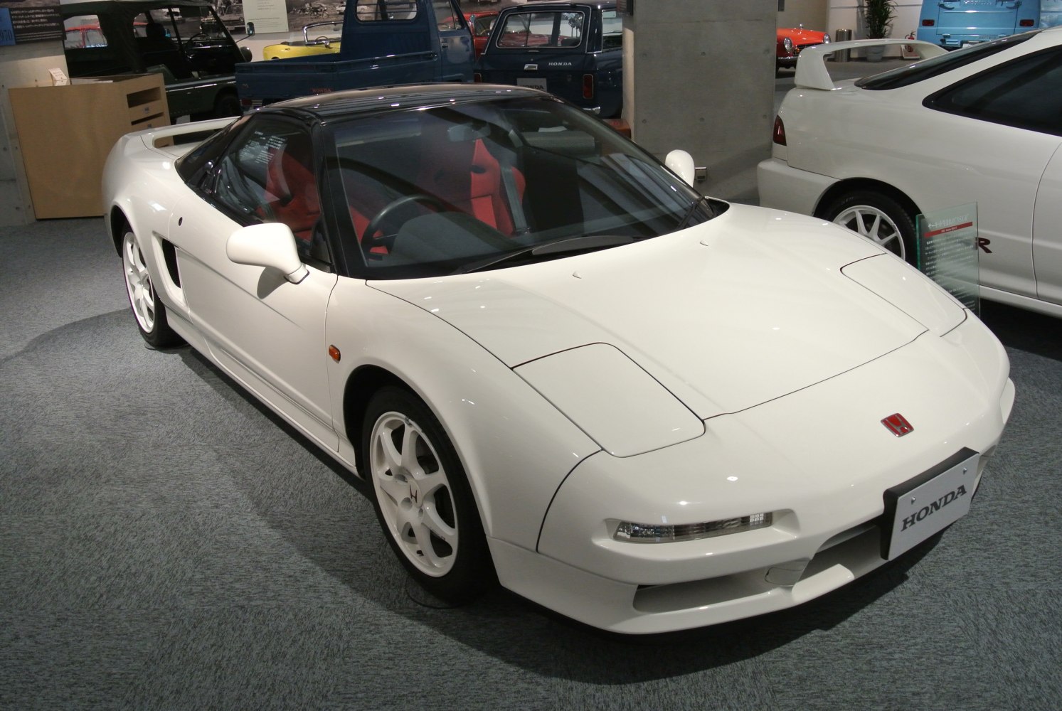 White sports coupe with black roof and red interior seats