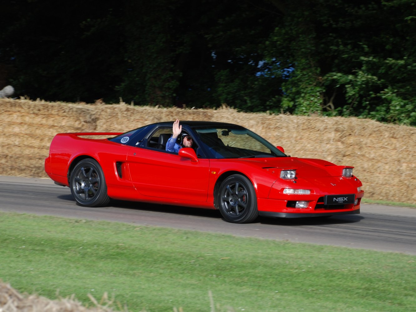 Red vintage sports coupe with pop-up headlights and black rims