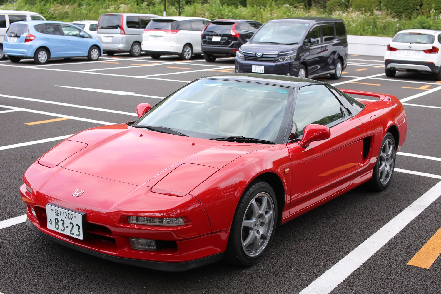 Red sports coupe with pop-up headlights and five-spoke wheels