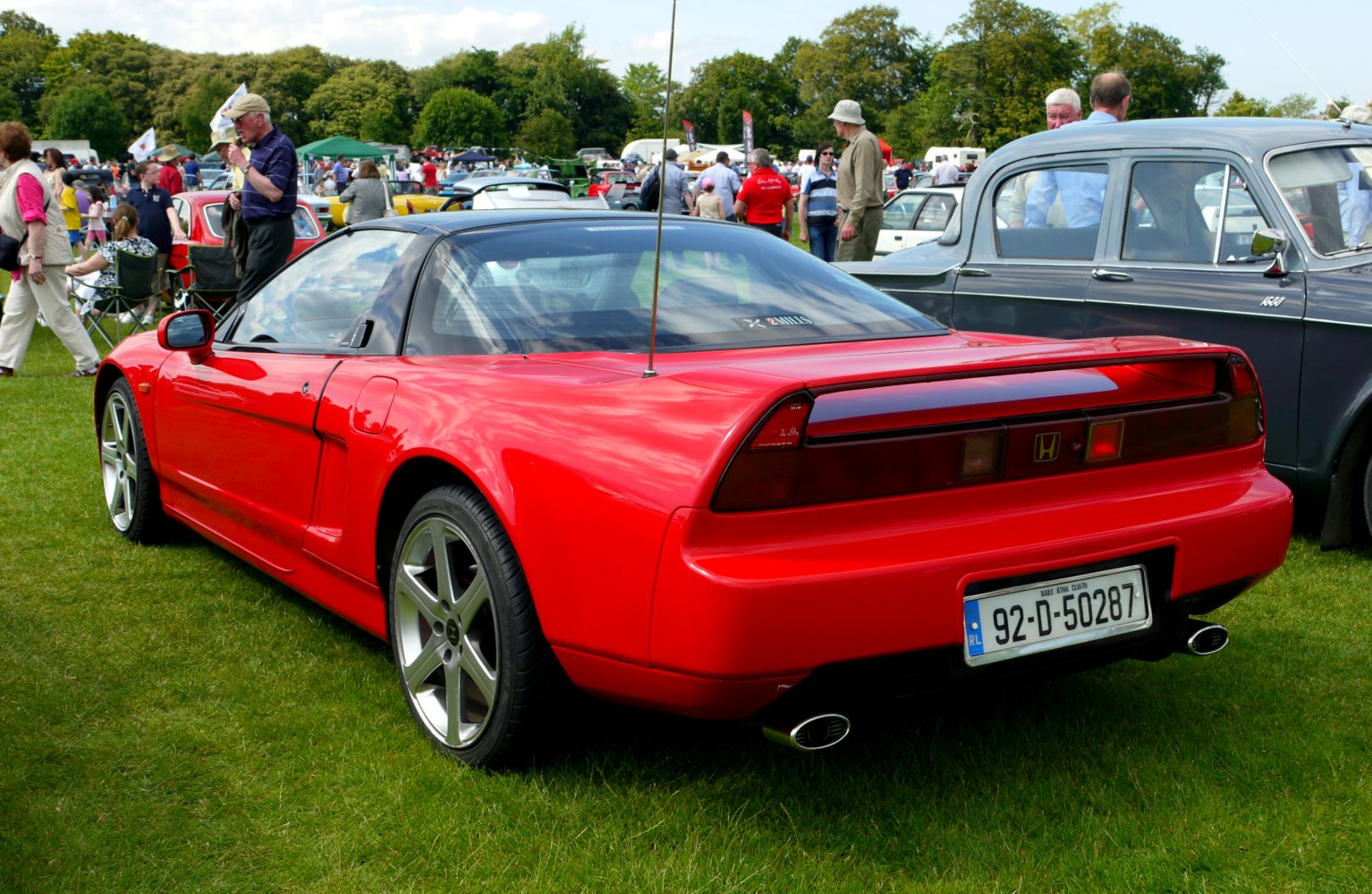 Rear view of a red sporty coupe with distinctive taillights and alloy wheels