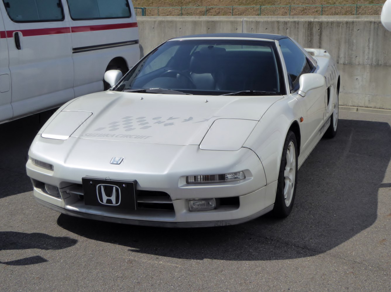 White sports coupe with pop-up headlights and aerodynamic front design.