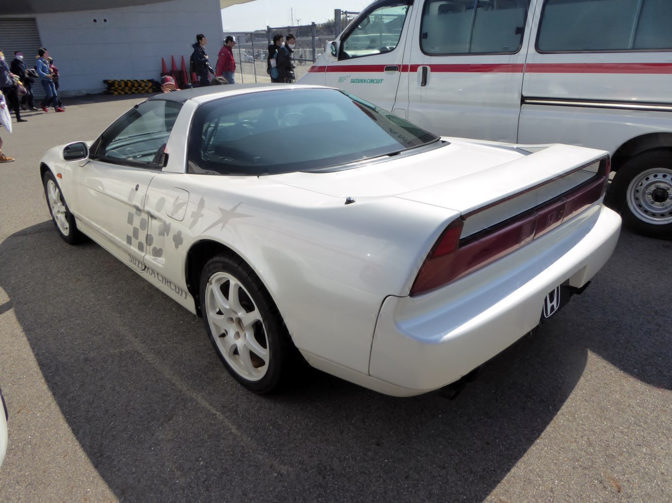 Rear 3/4 view of a white sports coupe with classic wedge shape and aerodynamic rear design