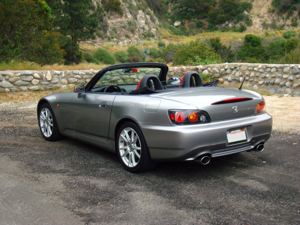 Silver convertible rear view with dual exhaust and open roof