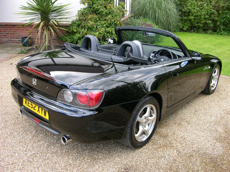 Convertible sports car rear with visible interior and rear lighting.
