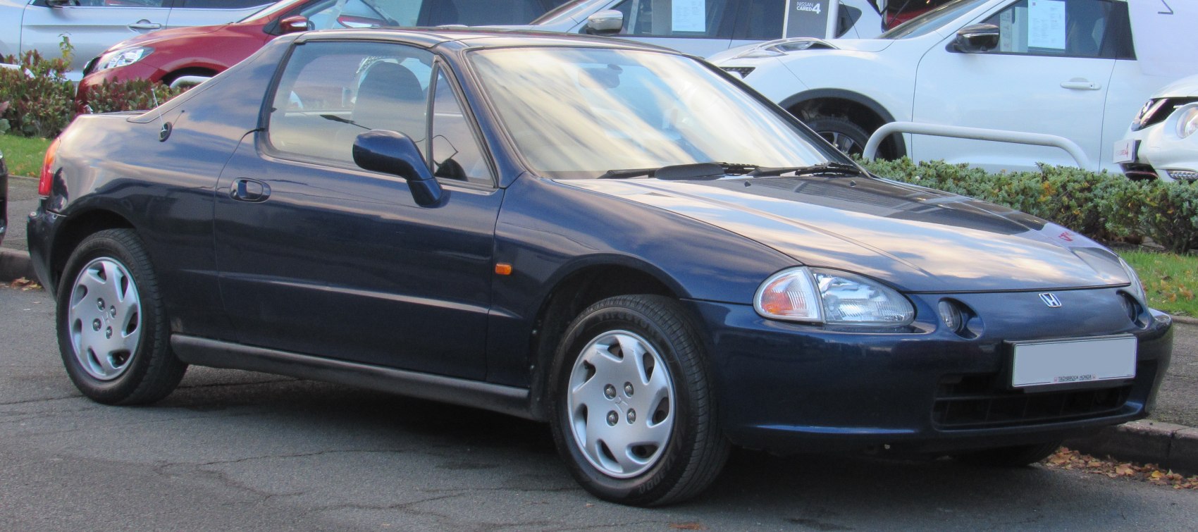 Front side view of compact coupe with distinct headlights and smooth aerodynamic shape