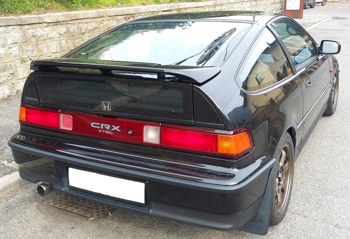 Rear view of a hatchback with spoiler and full-width taillights