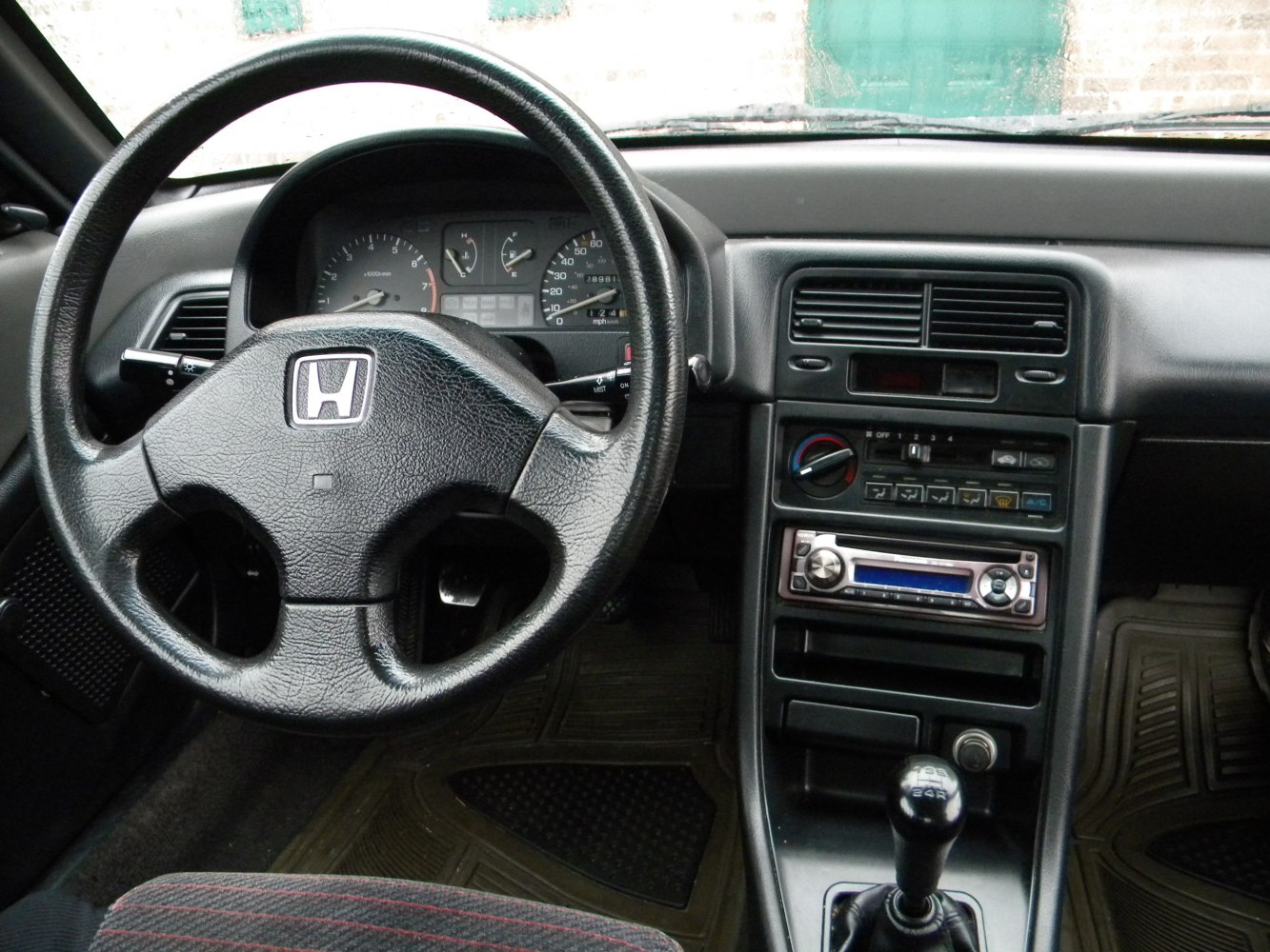 Steering wheel, dashboard cluster, manual gear shift.