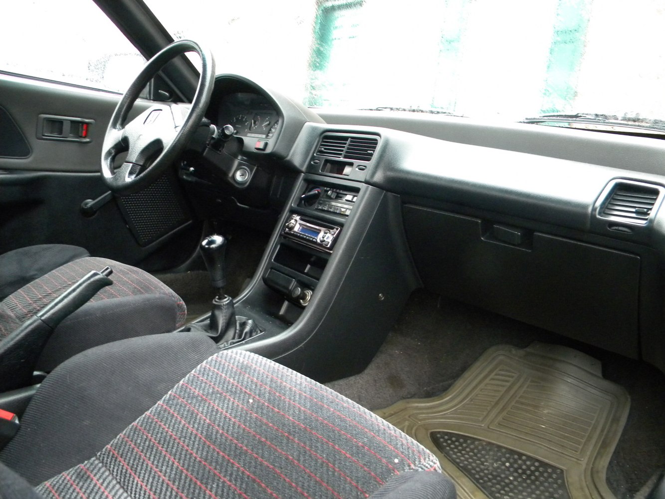 Dashboard, steering wheel, manual gear shift, patterned fabric seats interior