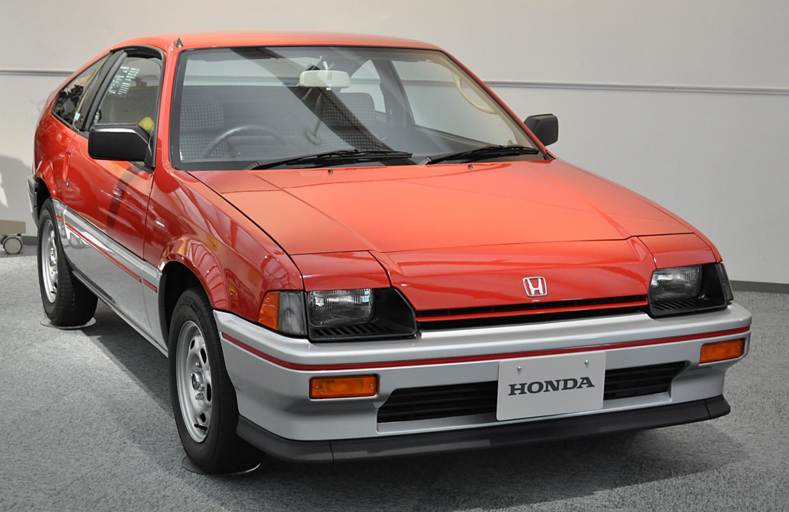 Front view with pop-up headlights and two-tone paint on hatchback.