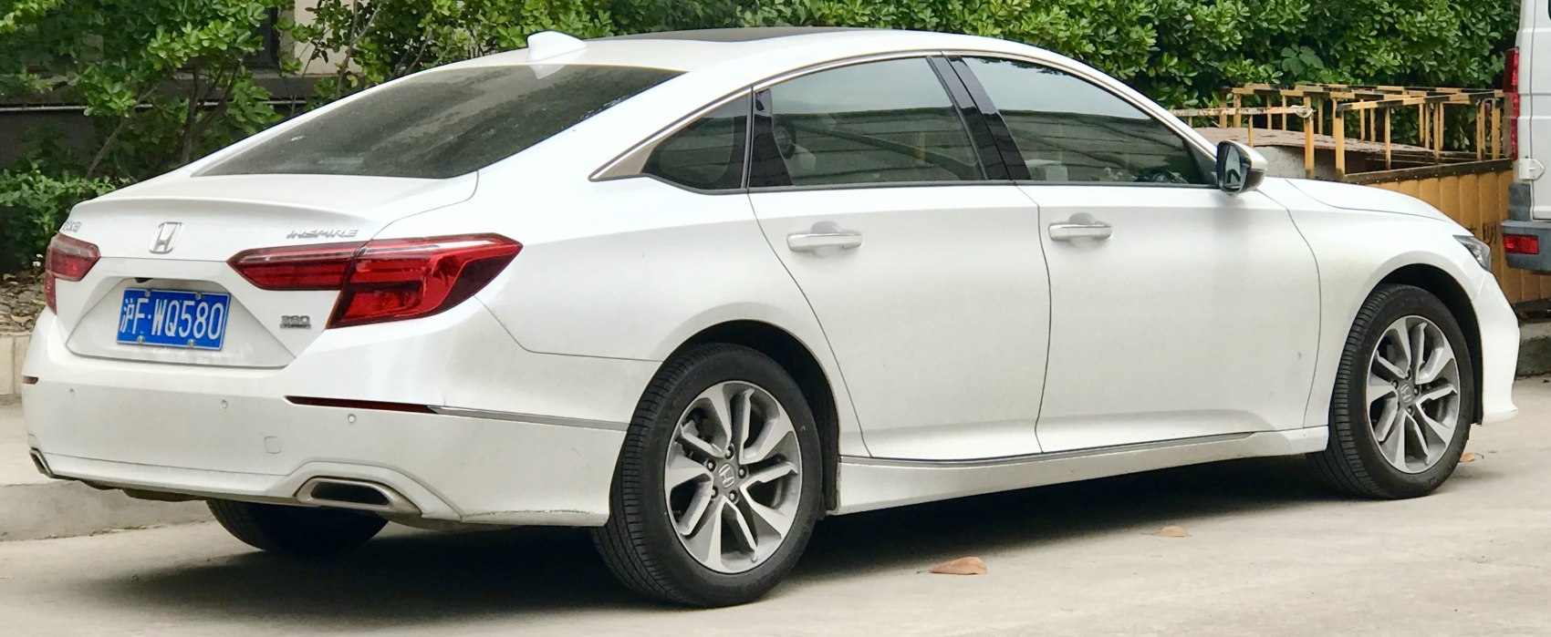 Rear and side view of white sedan with distinct tail lights and alloy wheels