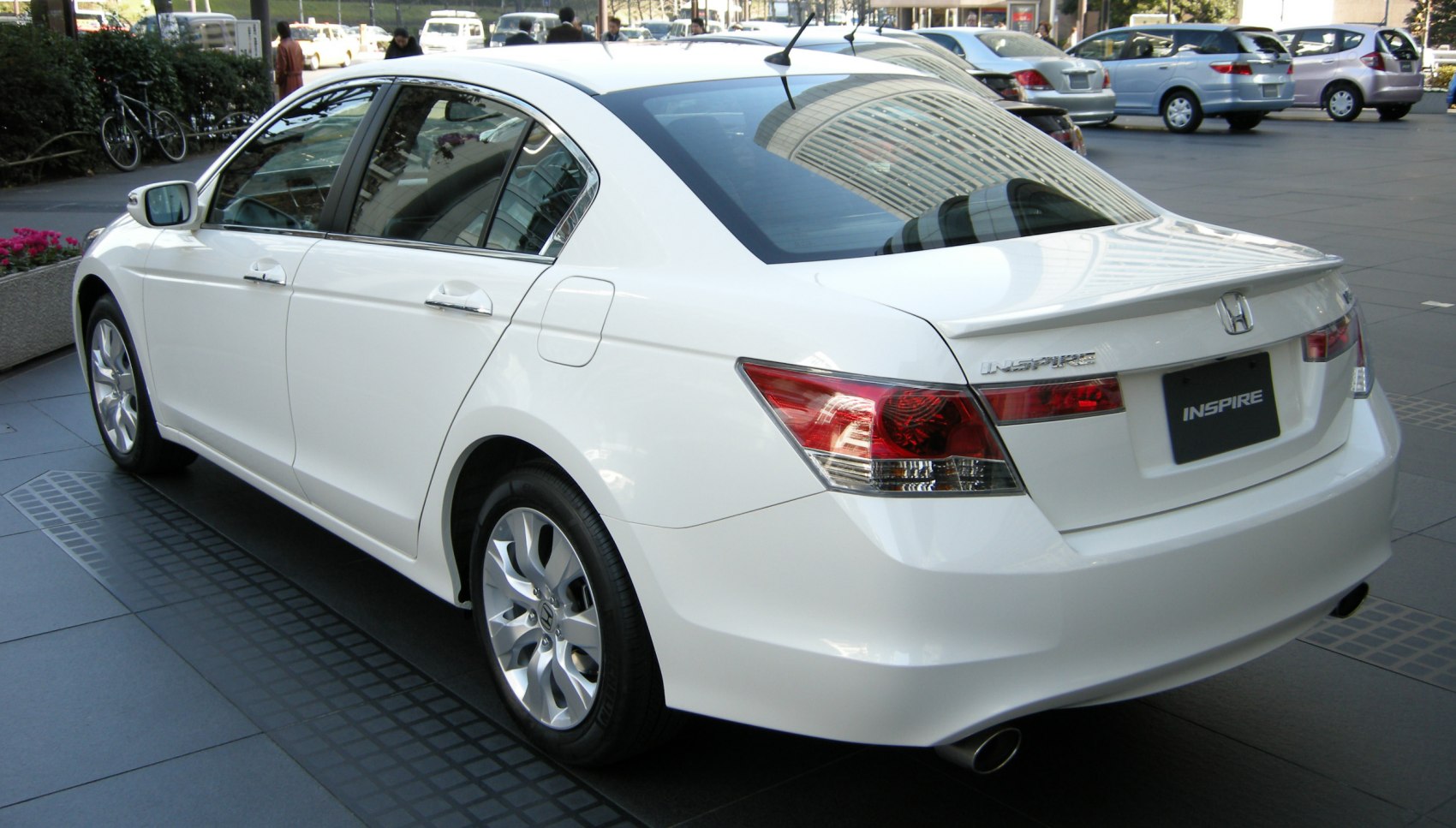 White sedan with rear spoiler and polished alloy wheels