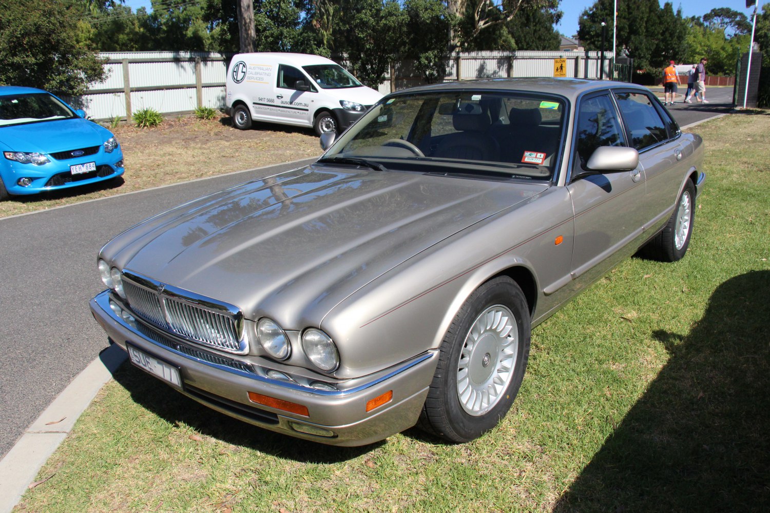Quad round headlights, chrome grille, alloy wheels, classic sedan front view