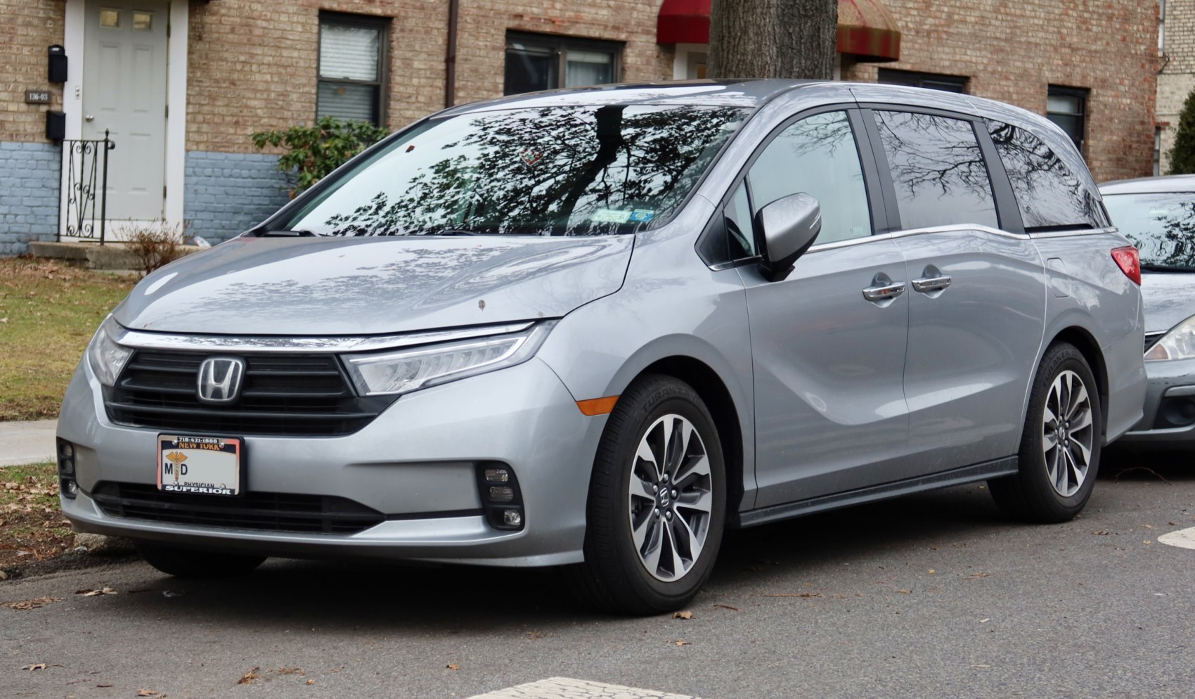 Silver minivan front view with prominent grille and headlights