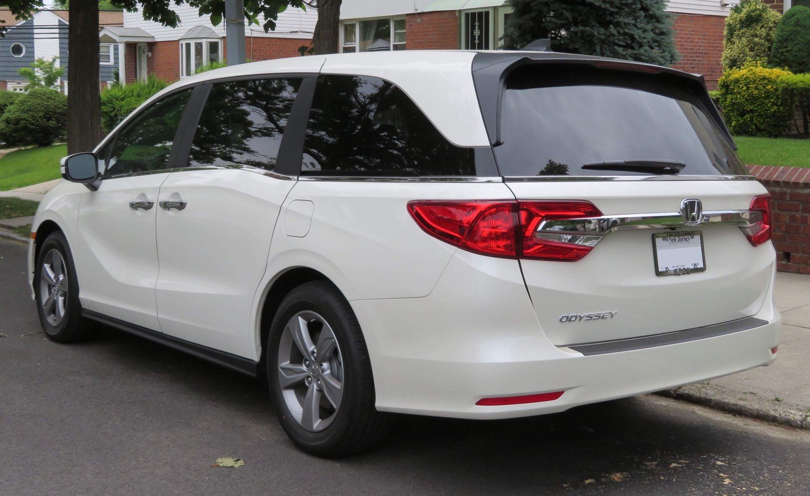 Rear and side view of white minivan with tinted windows and distinctive taillights