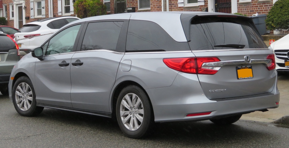 Rear side of minivan with distinctive tail lights and chrome trim