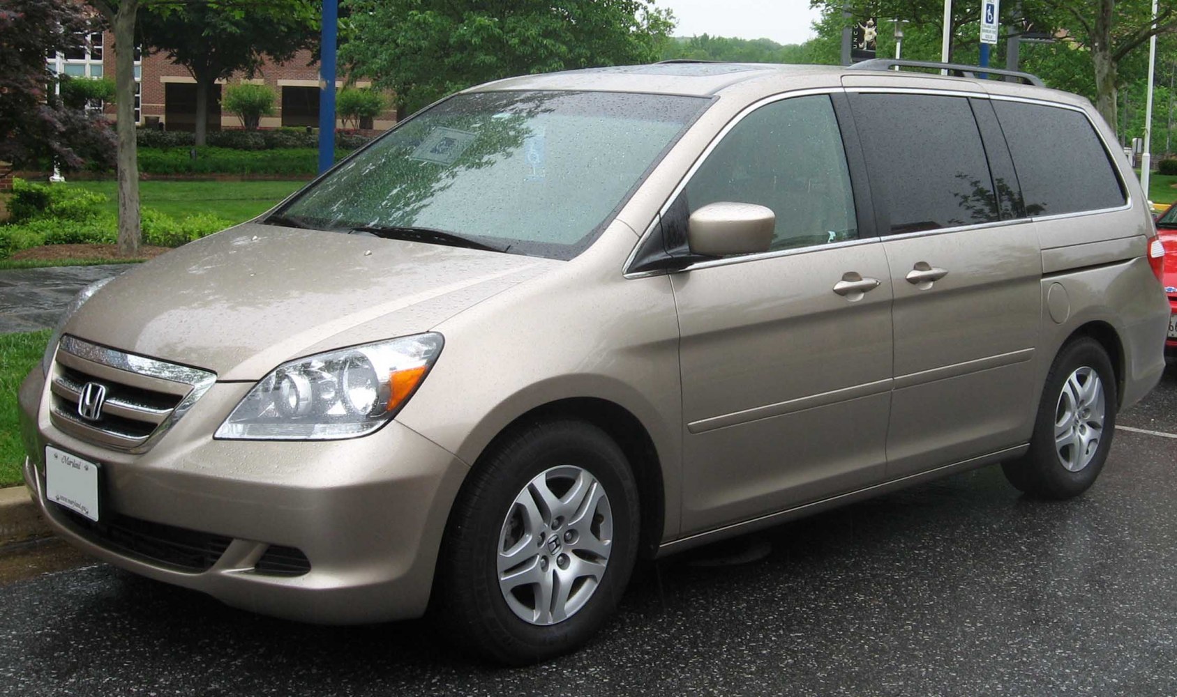Minivan exterior in rain, showcasing front and side profiles