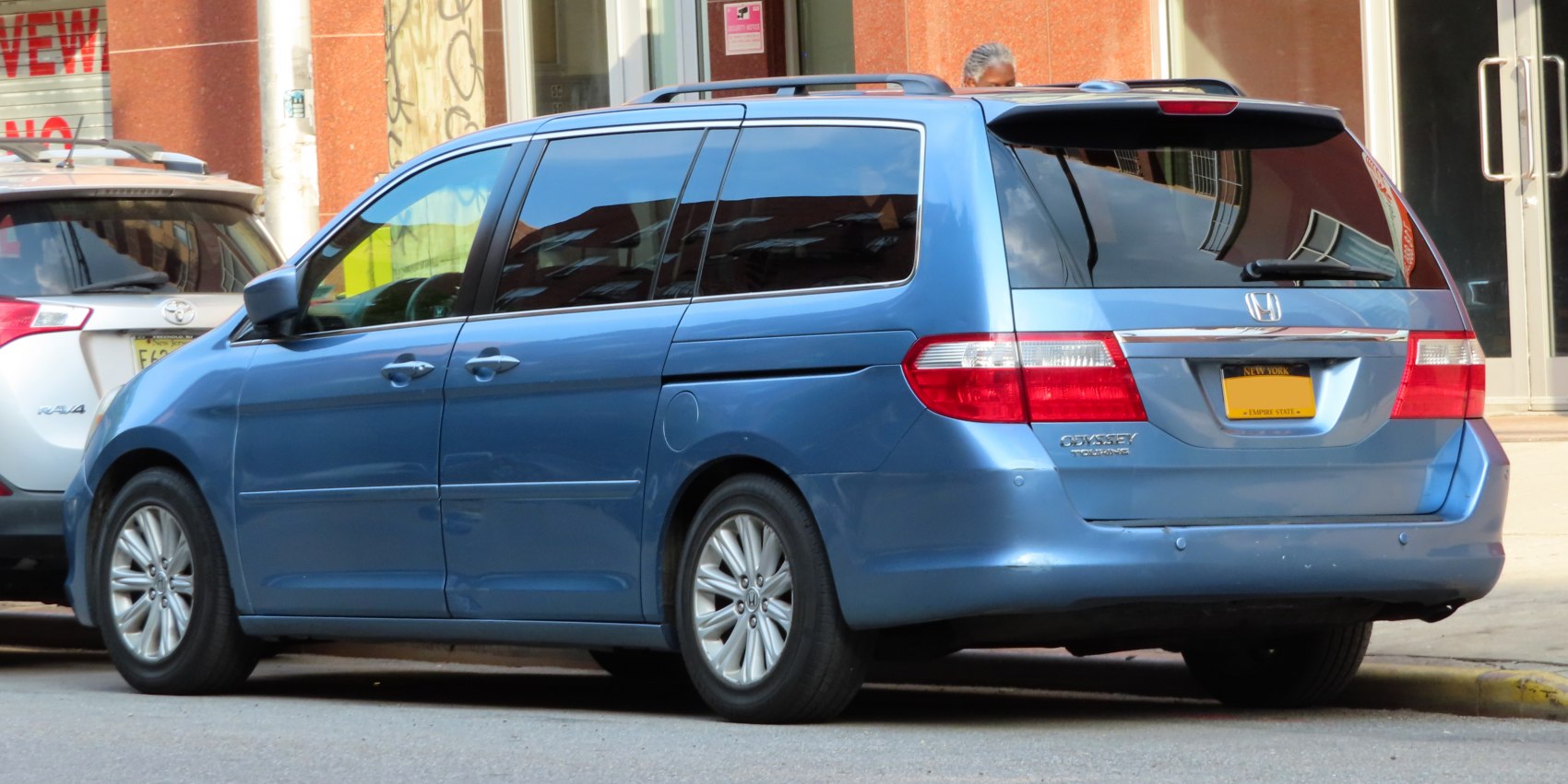 Blue minivan rear side with sliding doors and roof rails